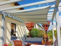 Toldo vela cuadrado impermeable 3x3 m Premium instalado sobre una terraza con muebles de exterior