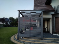 Voile d'ombrage de tonnelle blanche montée sur le toit d'une pergola de terrasse moderne en graphite sur fond de jardin