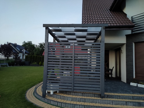 Voile d'ombrage de tonnelle blanche montée sur le toit d'une pergola de terrasse moderne en graphite sur fond de jardin