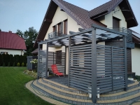 Bande d'ombrage gris cendré installée sur une pergola en bois moderne sur la terrasse d'une maison
