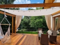 Voile d'ombrage rectangulaire blanc 3,2x2,5 m installé au-dessus d'une terrasse en bois avec mobilier de jardin
