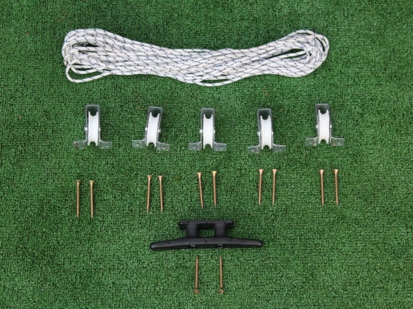 Kit pour stores romains avec cordon blanc, cinq poulies, taquet noir et vis sur fond vert