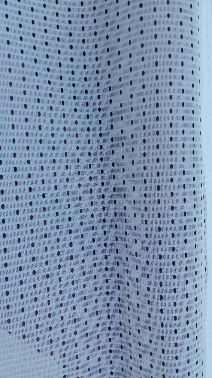 Cortina blanca para terraza con estructura de malla fina y agujeros regulares para el flujo de aire