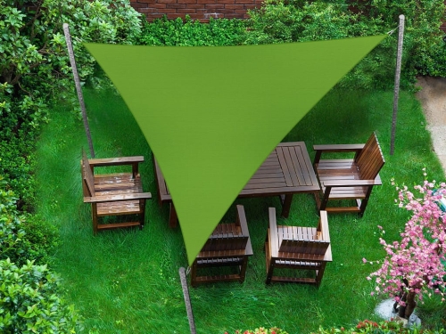 Toldo vela triangular verde sobre un conjunto de muebles de madera en el césped del jardín