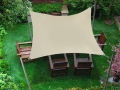 Voile d'ombrage carrée beige 3x3 m au-dessus des meubles de terrasse dans le jardin