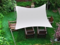 Voile d'ombrage imperméable 3x3 m suspendue au-dessus des meubles de terrasse dans un jardin