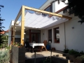Rulou roman de terasă impermeabil Premium 2,5x4 m montat pe o pergolă din lemn deasupra zonei de relaxare