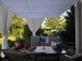 Rulou roman de terasă Premium alb 2,5x4 m deasupra unui set de mobilier de grădină pe terasă