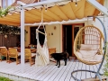 Rulou roman pentru terasă Premium impermeabil în culoarea nisipului deasupra unei terase din lemn cu mobilier de grădină