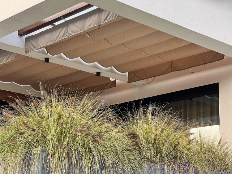 Store romain de terrasse Premium beige installé sur un toit blanc au-dessus de plantes de jardin