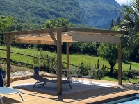 Store romain de terrasse beige imperméable Premium 3x4 m monté sur une pergola en bois au bord d'une piscine