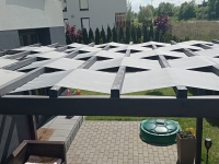 Vodotěsný pás na pergolu Premium 0,5x5 m - šedá sluneční clona propletená dřevěnými trámy.