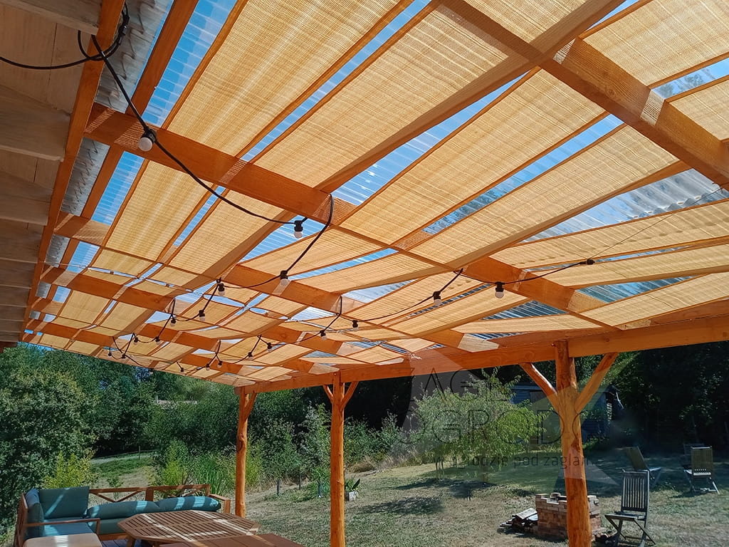 Toldo vela de color arena de tejido HDPE instalado en una estructura de madera para terraza