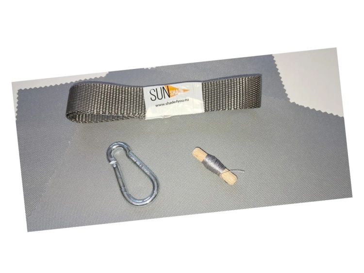 Sonnensegel-Reparaturset mit Karabiner, Gurtband und Garn auf grauem Stoffhintergrund