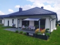 Grijs schaduwdoek waterdicht gemonteerd boven het terras van een moderne eengezinswoning