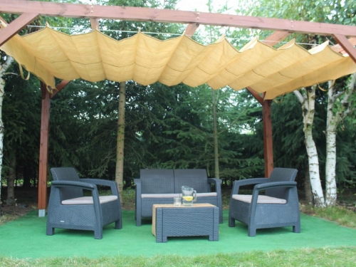 Beiges Raffrollo aus HDPE als Sonnenschutz an einer Holzpergola über Gartenmöbeln montiert