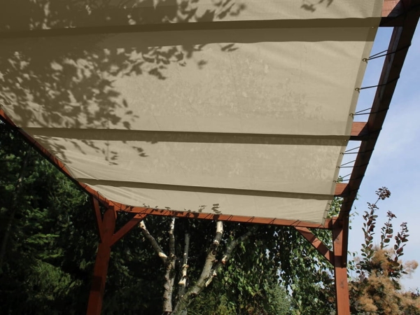 Voile d'ombrage HDPE blanc sur mesure monté sur une pergola en bois dans un jardin offrant une ombre agréable