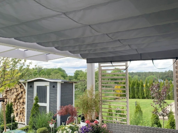 Store bateau horizontal gris installé sous le toit de la terrasse dans une véranda