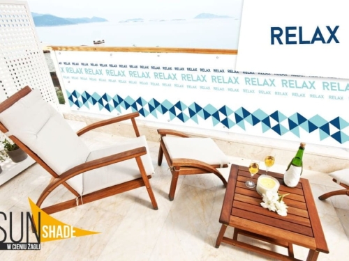 Werbe-Balkonumspannung mit Relax-Aufdruck und geometrischem Muster auf sonniger Terrasse mit Gartenmöbeln