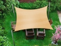 Voile d'ombrage carrée beige en HDPE 5x5 m au-dessus de meubles de jardin en bois sur la pelouse