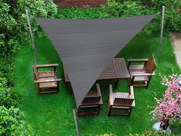 Szary trójkątny żagiel przeciwsłoneczny 4,2x4,2x5,9 m nad drewnianymi meblami ogrodowymi na trawniku