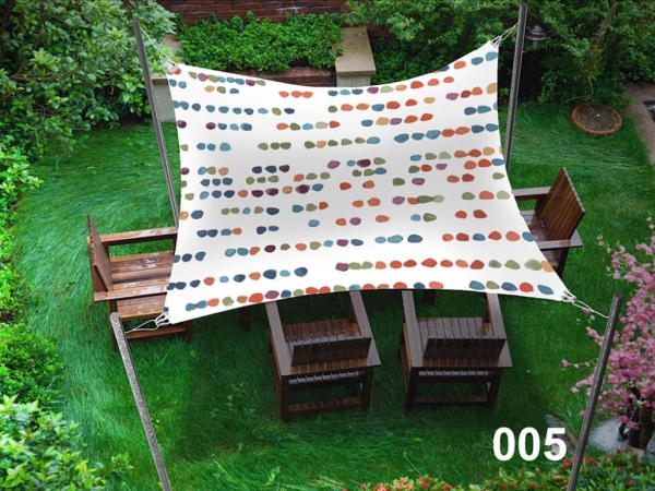 Voile d'ombrage imperméable 3x4 m à pois colorés au-dessus de meubles en bois sur une pelouse verte