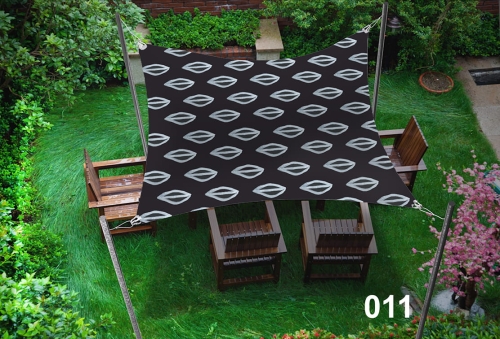 Voile d'ombrage imperméable 3x4,5 m de couleur foncée avec motif blanc, installée au-dessus de meubles en bois sur une pelouse