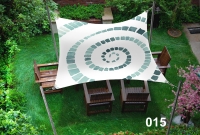 Voile d'ombrage rectangulaire 3x4,5 m avec motif spirale vert au-dessus de meubles en bois dans un jardin