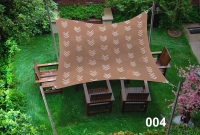 Voile d'ombrage marron 3x5 m avec motif blanc, protégeant des meubles en bois sur une pelouse verte