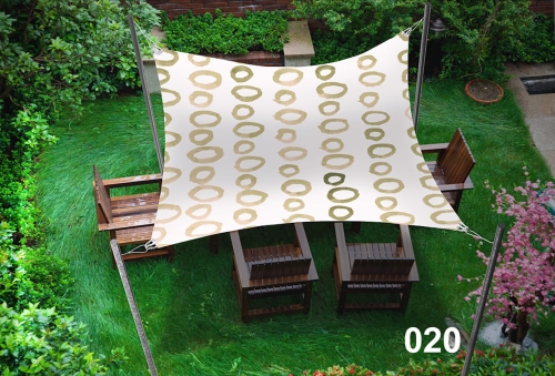 Voile d'ombrage imperméable 3x5 m à motifs cercles dorés au-dessus de fauteuils en bois sur la pelouse