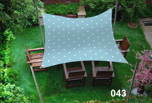 Voile d'ombrage imperméable à pois 3x5 m au-dessus d'un salon de jardin en bois sur l'herbe