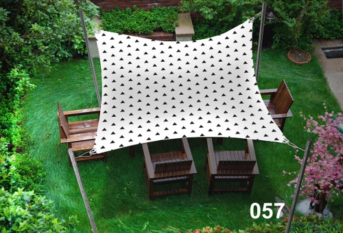 Voile d'ombrage imperméable 3x5 m avec triangles noirs au-dessus de meubles de jardin en bois sur une pelouse