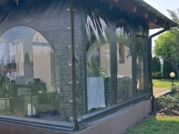 Bâche de terrasse transparente avec impression imitation pierre, équipée de fenêtres et de supports de fixation