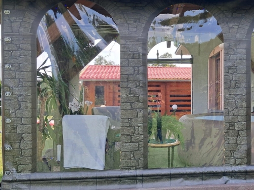 Bâche de terrasse transparente avec impression imitation mur de pierre et fenêtres cintrées sur mesure