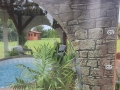 Prelată transparentă pentru terasă cu imprimeu de zid care protejează un jacuzzi în grădină cu vedere la foișor și plante
