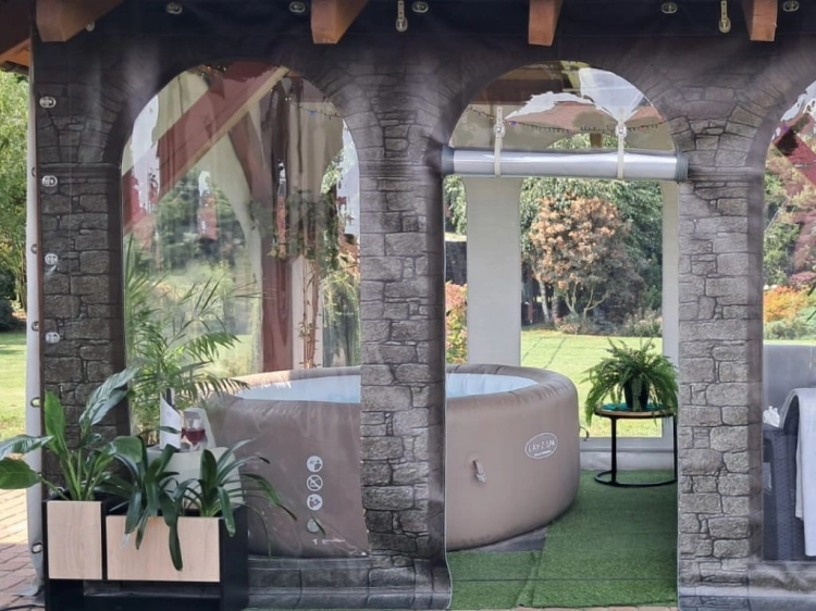 Bâche de terrasse transparente avec motif de mur protégeant un jacuzzi gonflable rond sous un abri