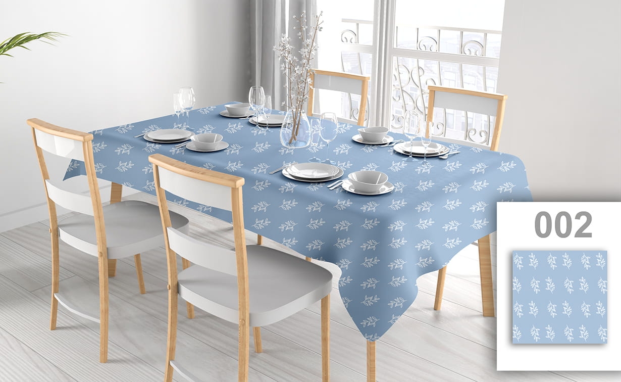 Fleckenabweisende blaue Werbetischdecke mit weißen Blättern auf einem Tisch im hellen Esszimmer mit weißen Stühlen