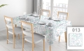 Vlekafstotend reclametafelkleed met pastelkleurige bloemen en bladeren op een tafel met wit servies en houten stoelen