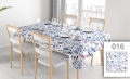 Vlekafstotend tafelkleed met blauw-roze veldbloemen op een witte tafel met servies in een lichte eetkamer