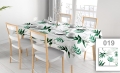 Wit vlekbestendig tafelkleed met groene bladeren print op een eettafel met witte stoelen