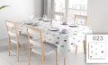 Wit vlekbestendig tafelkleed met gekleurde stippen op een eettafel met vier stoelen en elegant servies
