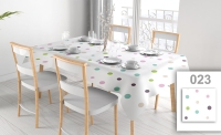 Weiße fleckabweisende Tischdecke mit bunten Punkten auf einem Esstisch mit vier Stühlen und elegantem Geschirr