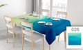 Vlekafstotend reclametafelkleed met blauw-groene golfprint op een tafel met wit servies en houten stoelen