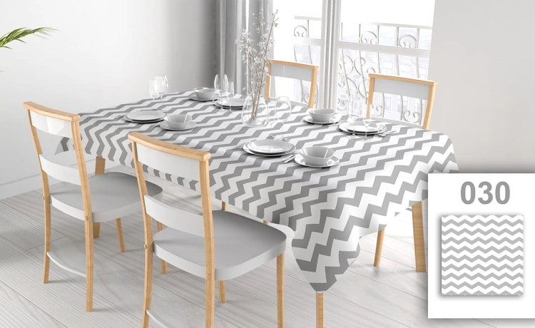Vlekafstotend reclametafelkleed met grijs-wit zigzagpatroon op een gedekte eettafel met witte stoelen
