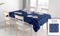Donkerblauw vlekbestendig tafelkleed met wit ankermotief op een eettafel met stoelen en servies bij het raam