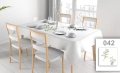 Vlekvrij wit reclametafelkleed met subtiele plantenprint op een tafel in een lichte eetkamer