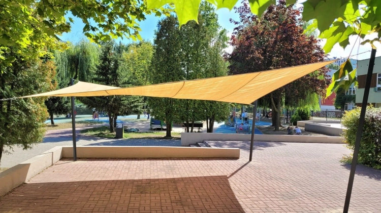 Voile d'ombrage jaune sur une aire de jeux, protégeant du soleil et des rayons UV