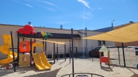 Voile d'ombrage jaune sur mesure protégeant une aire de jeux en sable du soleil et des rayons UV