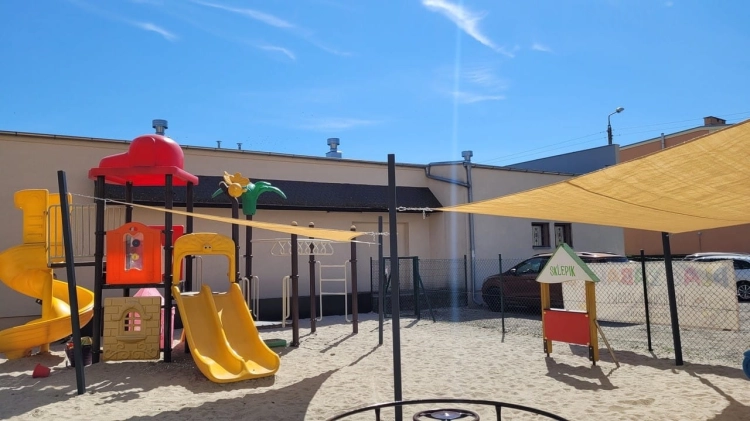 Voile d'ombrage jaune sur mesure protégeant une aire de jeux en sable du soleil et des rayons UV