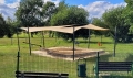 Sabbiera in un parco giochi riparata da una vela ombreggiante beige su misura montata su pali